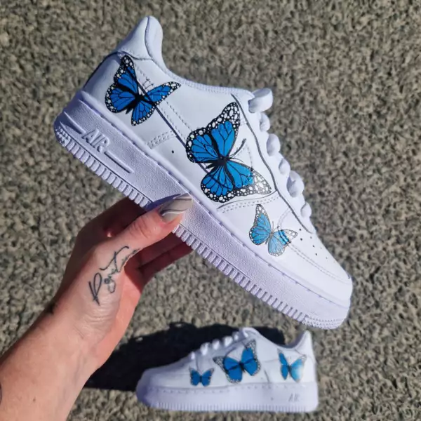 Nike Air Force 1 custom avec papillons bleus de tailles différentes peints à la main sur chaque chaussure
