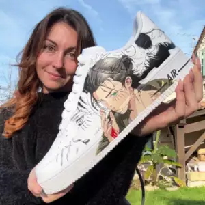 PhotoDeMoiPageFaq L’artiste tenant une sneaker personnalisée à la main sur le thème Attack des Titans avec Eren Titan peint.